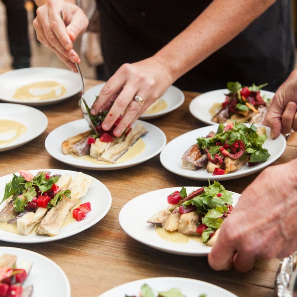 Photo of hands plating food for event