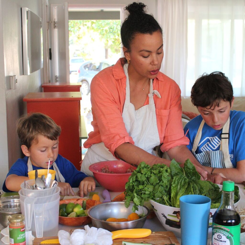 Adult helping children with cooking