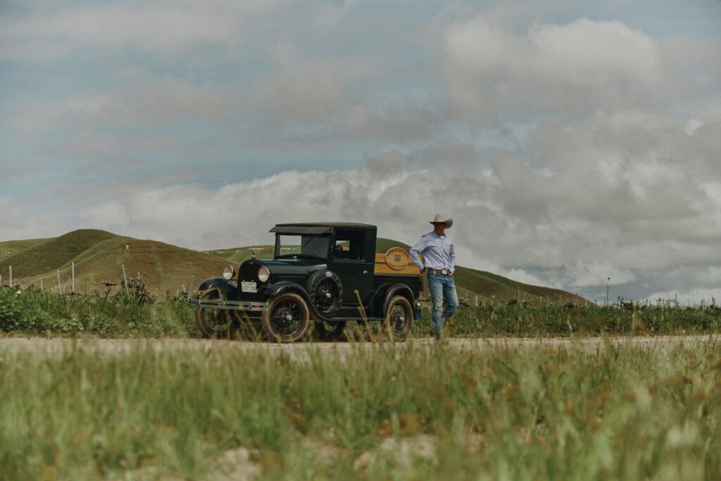 Photo of cowboy and old vehicle