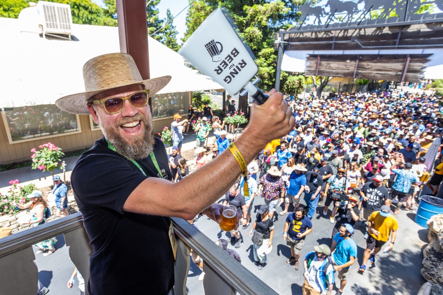 Man rings bell with crowd in background