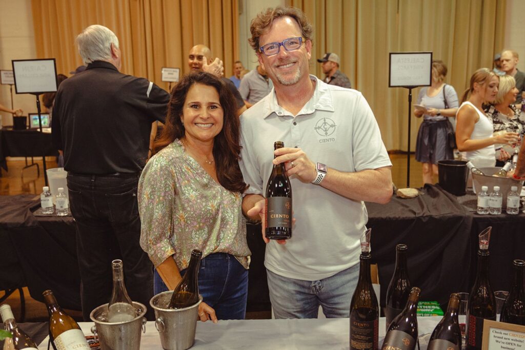 Photo of two people holding wine.