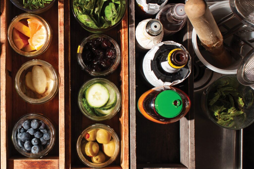 Garnishes are prepped behind the bar.