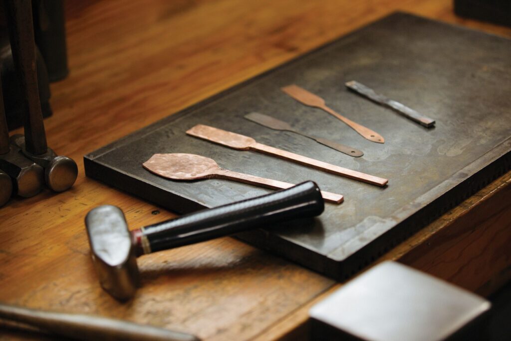 A soup spoon and salad fork in progress; two fork templates, sterling silver forging stock.